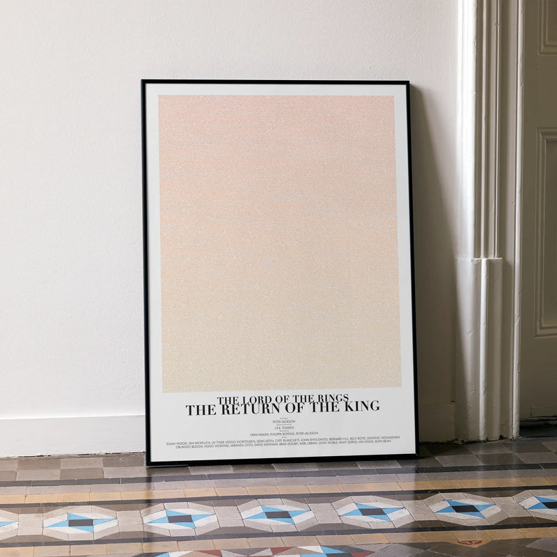 A framed The Lord of the Rings: The Return of the King movie script poster leaning against a wall in a minimalist interior.