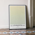 A framed The Lord of the Rings: The Fellowship of the Ring movie script poster leaning against a wall in a minimalist interior.
