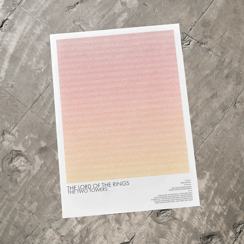 A The Lord of the Rings: The Two Towers movie script poster laid flat on a textured floor surface.