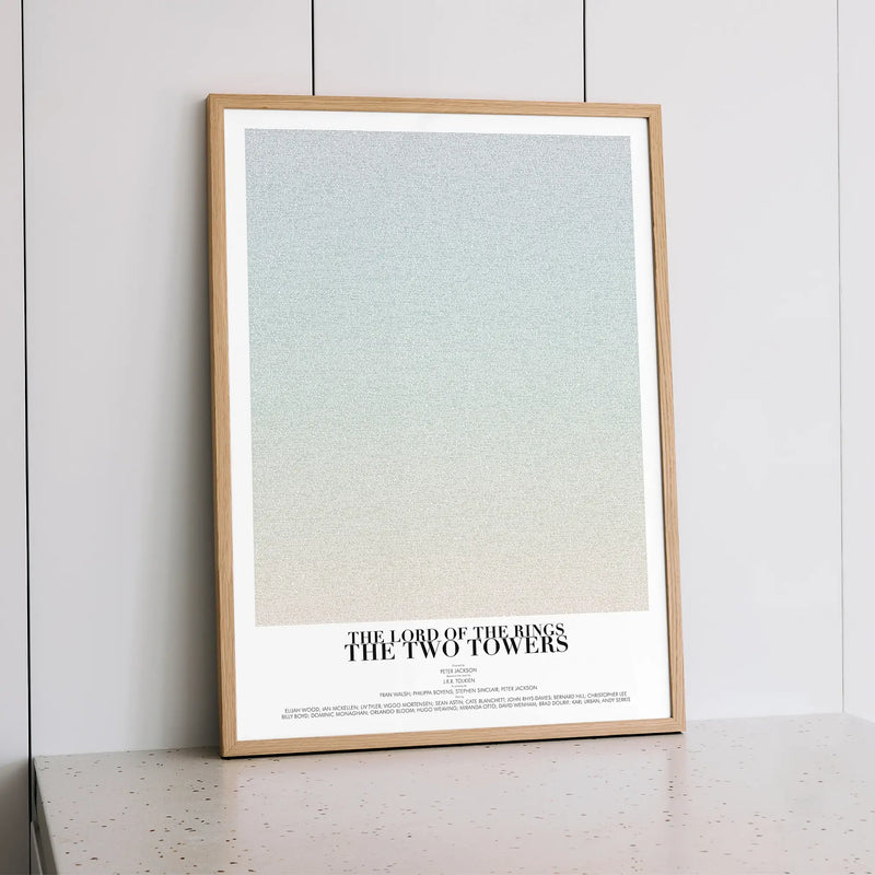 A framed The Lord of the Rings: The Two Towers movie script poster styled within a calm interior space.