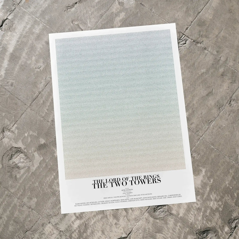 A The Lord of the Rings: The Two Towers movie script poster laid flat on a textured floor surface.