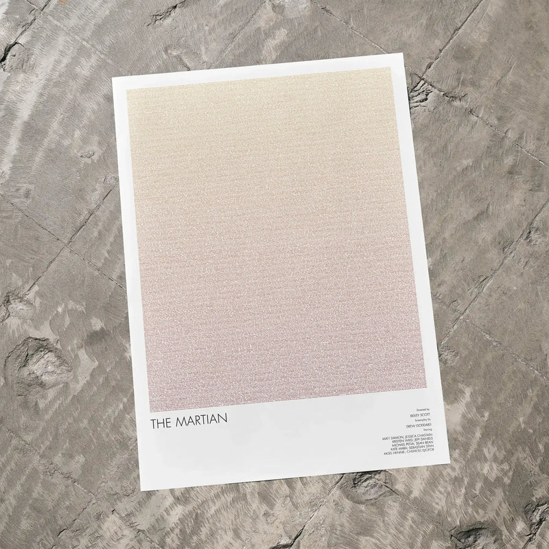 A The Martian movie script poster laid flat on a textured floor surface.