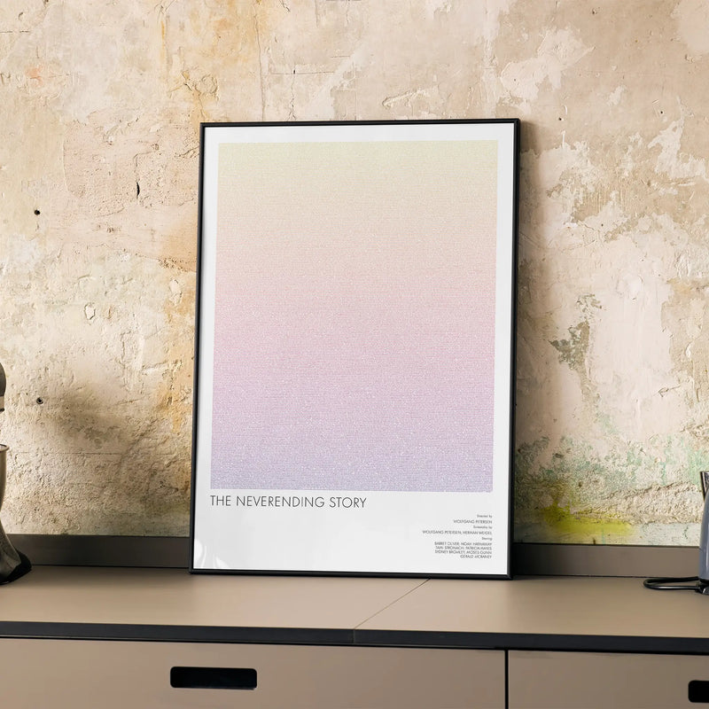 A framed The NeverEnding Story movie script poster displayed on a cabinet in a minimalist interior.