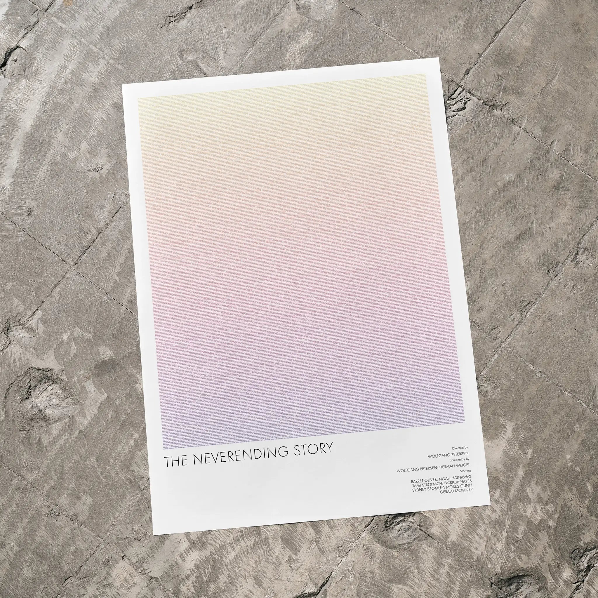 A The NeverEnding Story movie script poster laid flat on a textured floor surface.