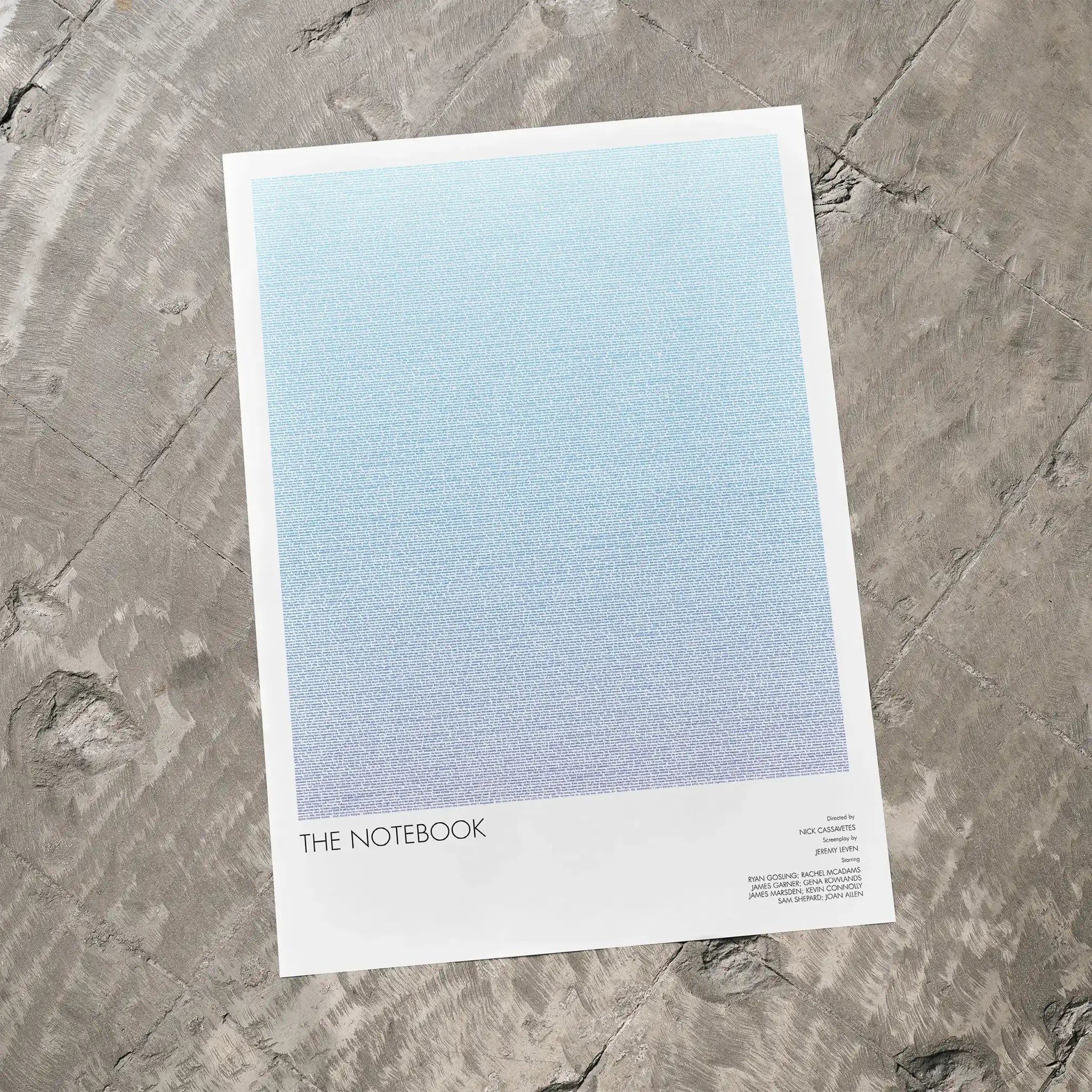 A The Notebook movie script poster laid flat on a textured floor surface.