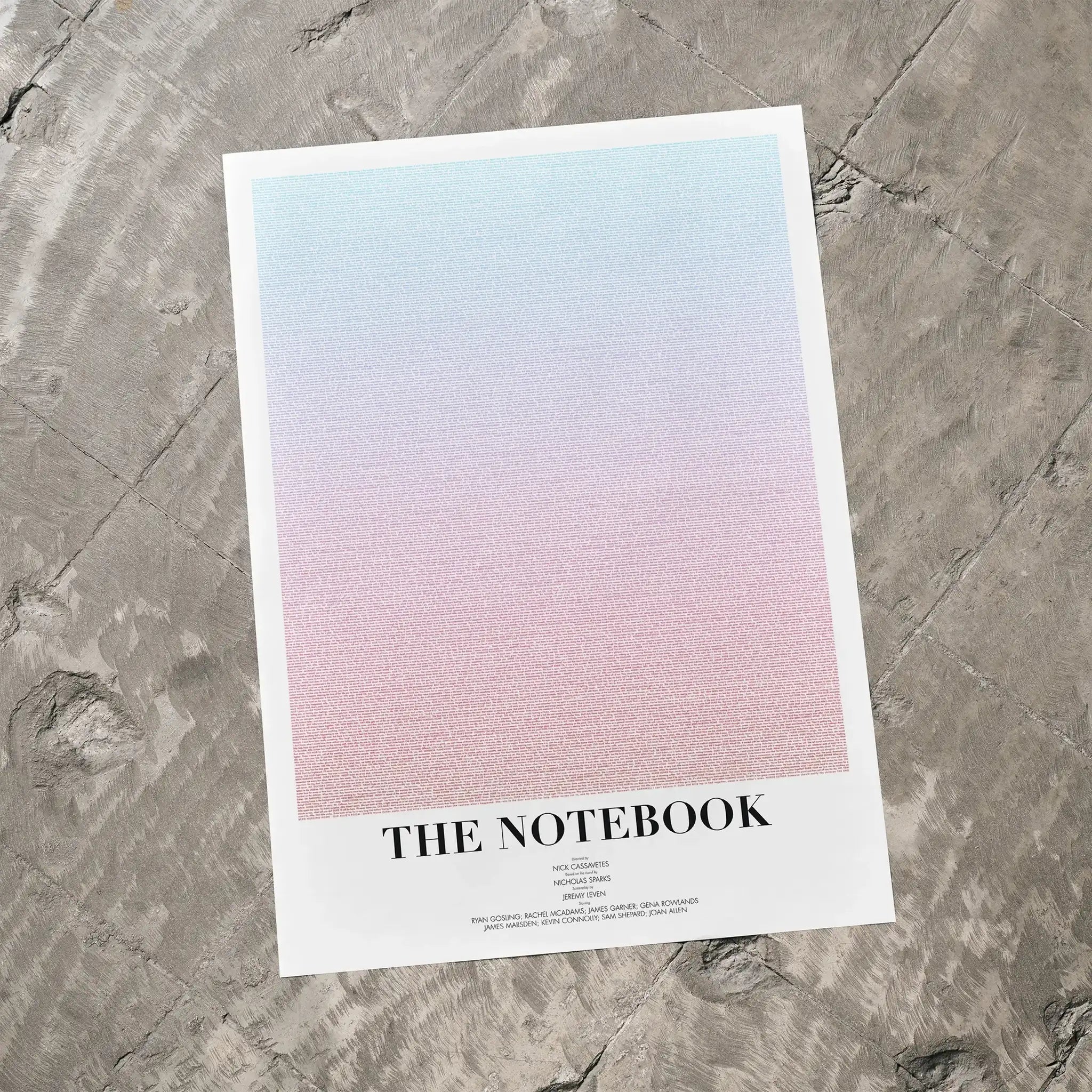 A The Notebook movie script poster laid flat on a textured floor surface.