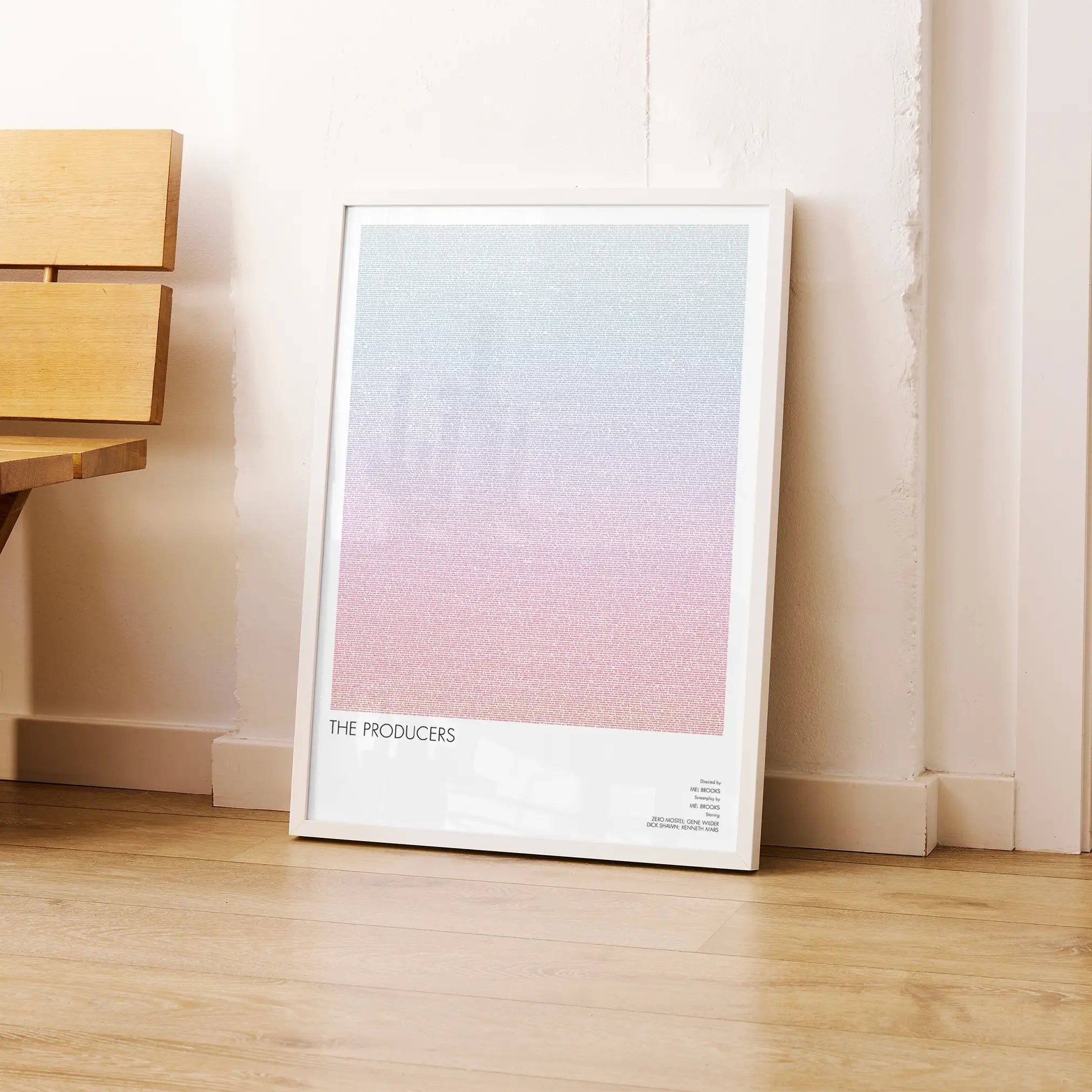 A framed The Producers movie script poster leaning against a wall in a modern interior.