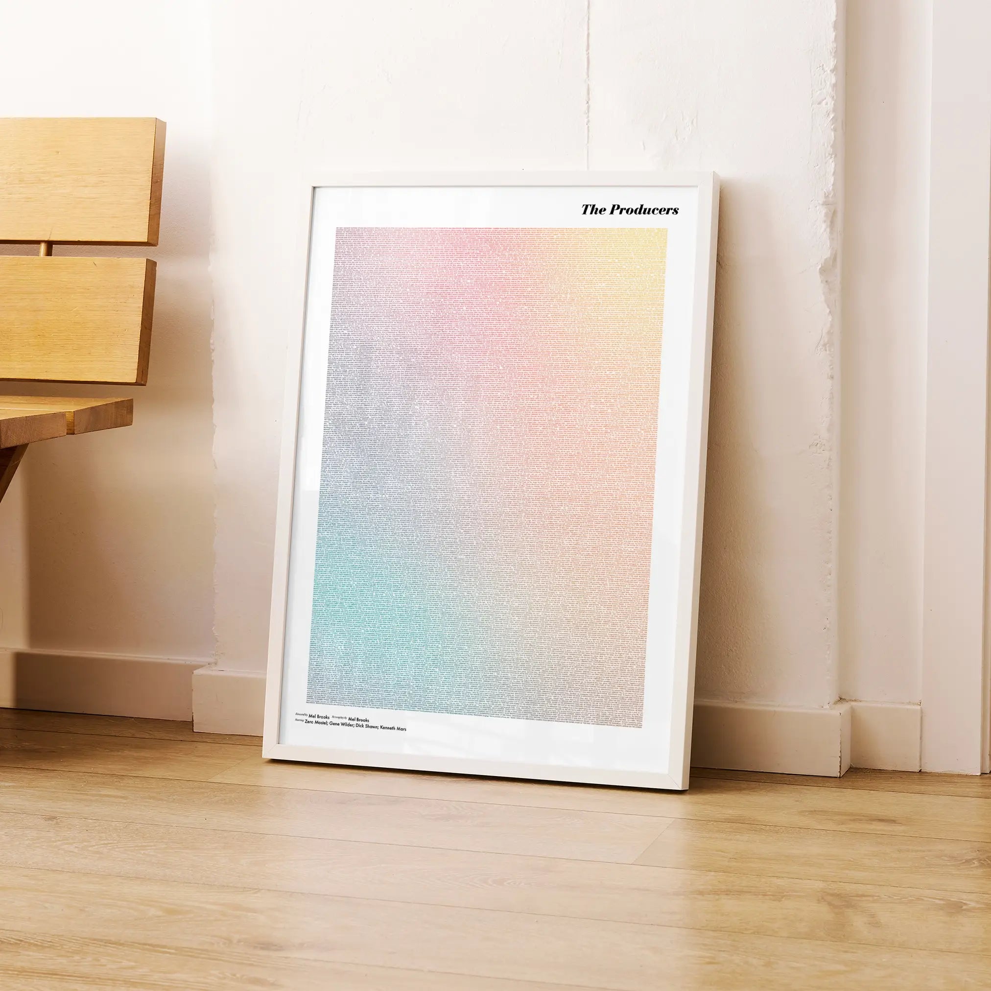 A framed The Producers movie script poster leaning against a wall in a modern interior.