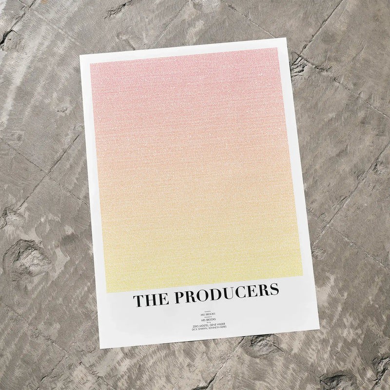 A The Producers movie script poster laid flat on a textured floor surface.