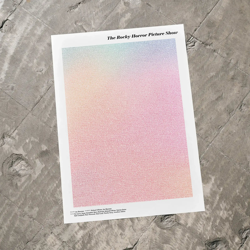 A The Rocky Horror Picture Show movie script poster laid flat on a textured floor surface.