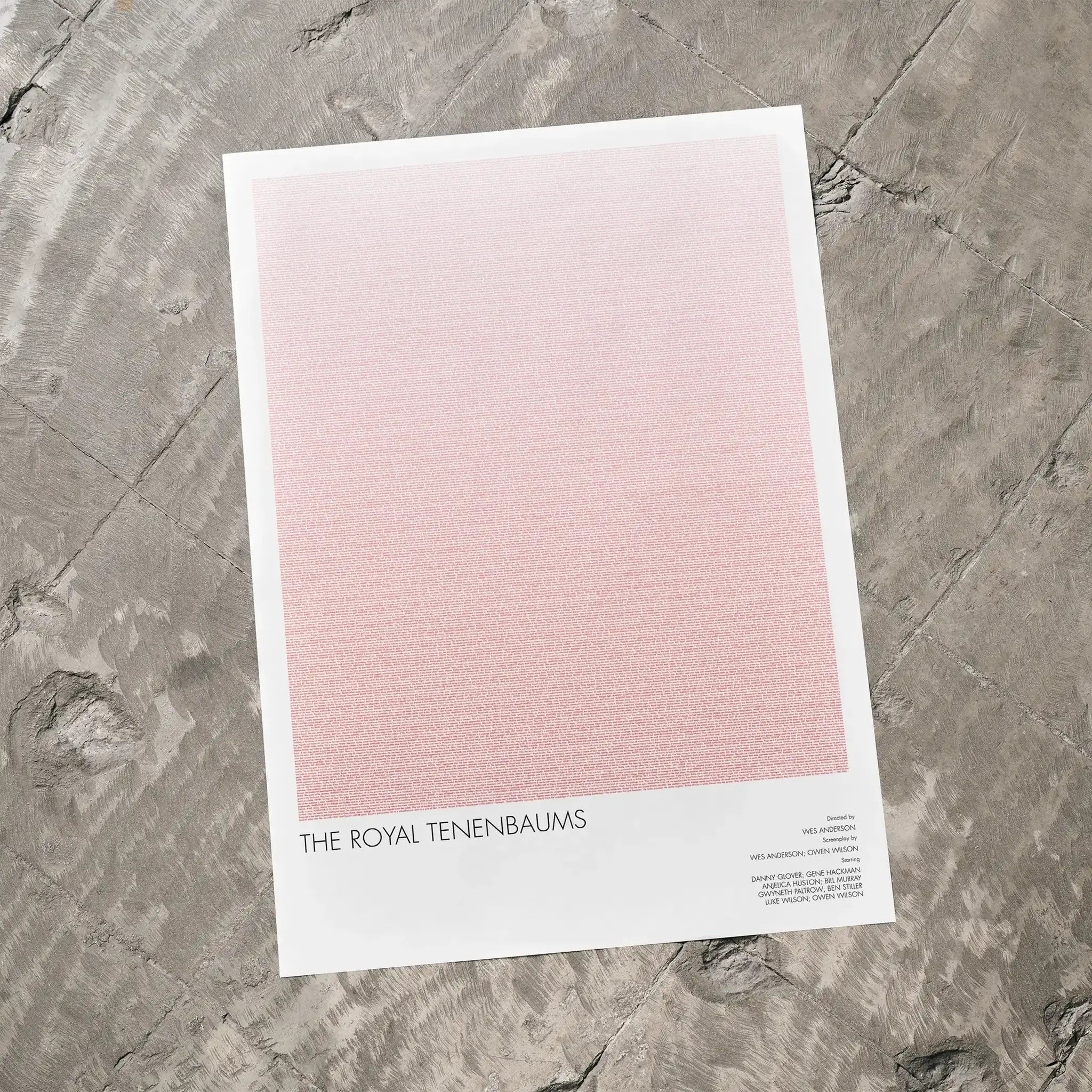 A The Royal Tenenbaums movie script poster laid flat on a textured floor surface.