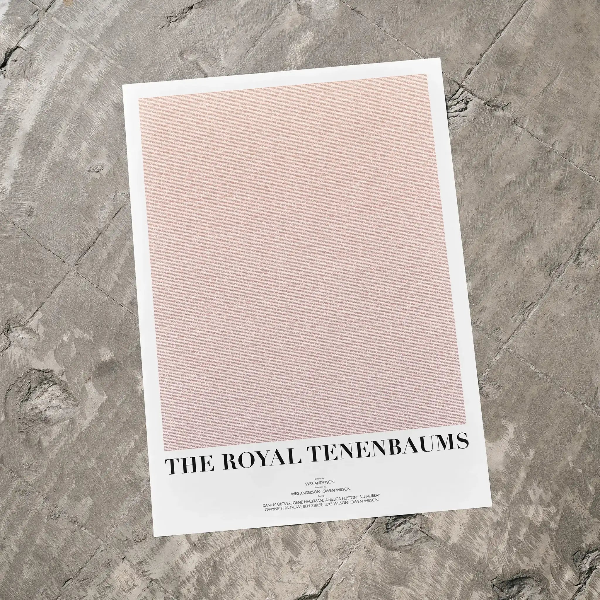 A The Royal Tenenbaums movie script poster laid flat on a textured floor surface.