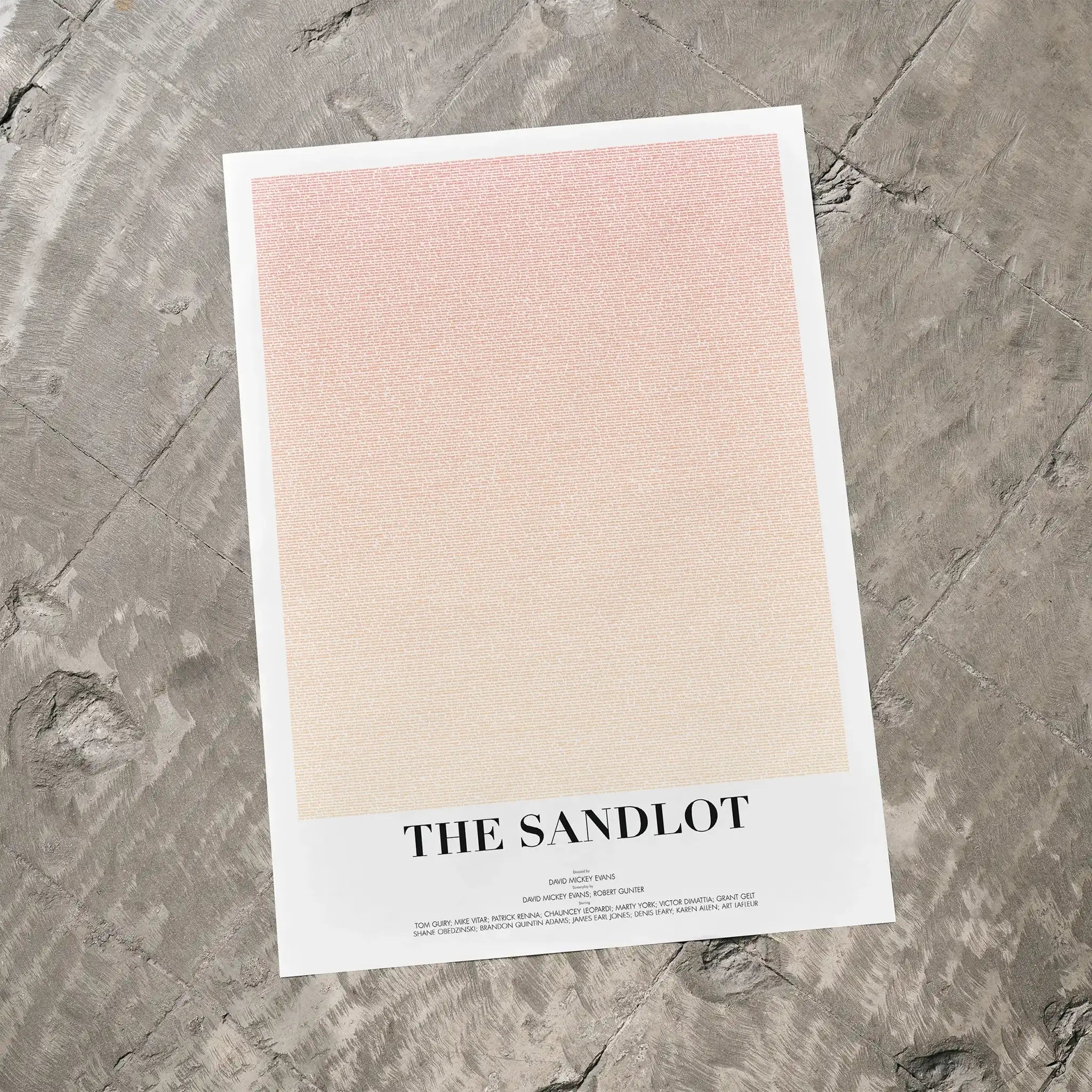 A The Sandlot movie script poster laid flat on a textured floor surface.