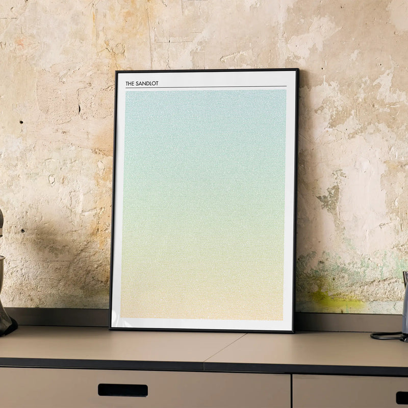 A framed The Sandlot movie script poster displayed on a cabinet in a minimalist interior.