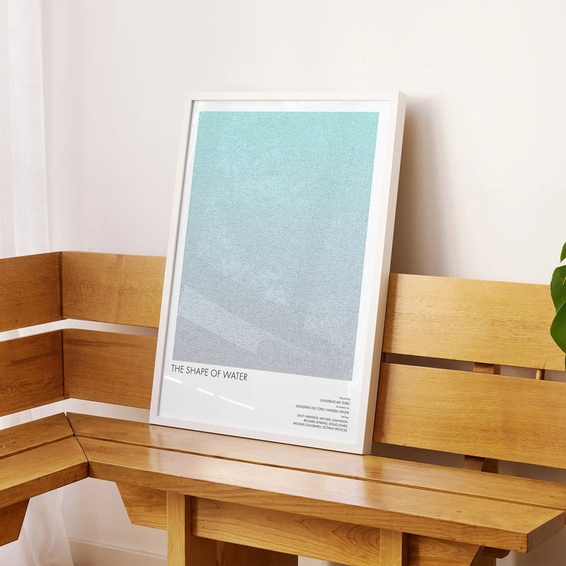 A framed The Shape of Water movie script poster displayed on a sideboard in a contemporary space.