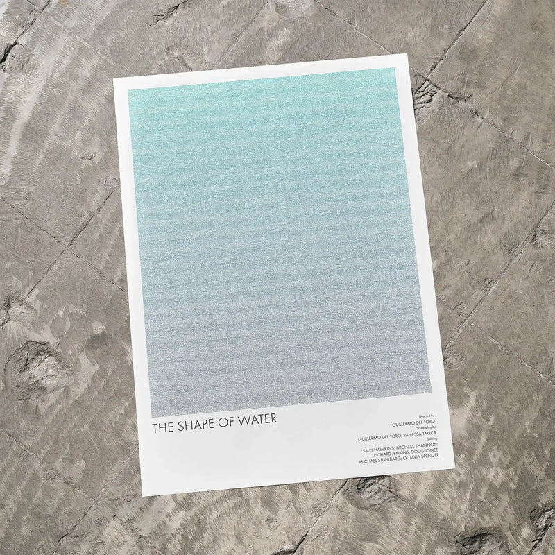 A The Shape of Water movie script poster laid flat on a textured floor surface.