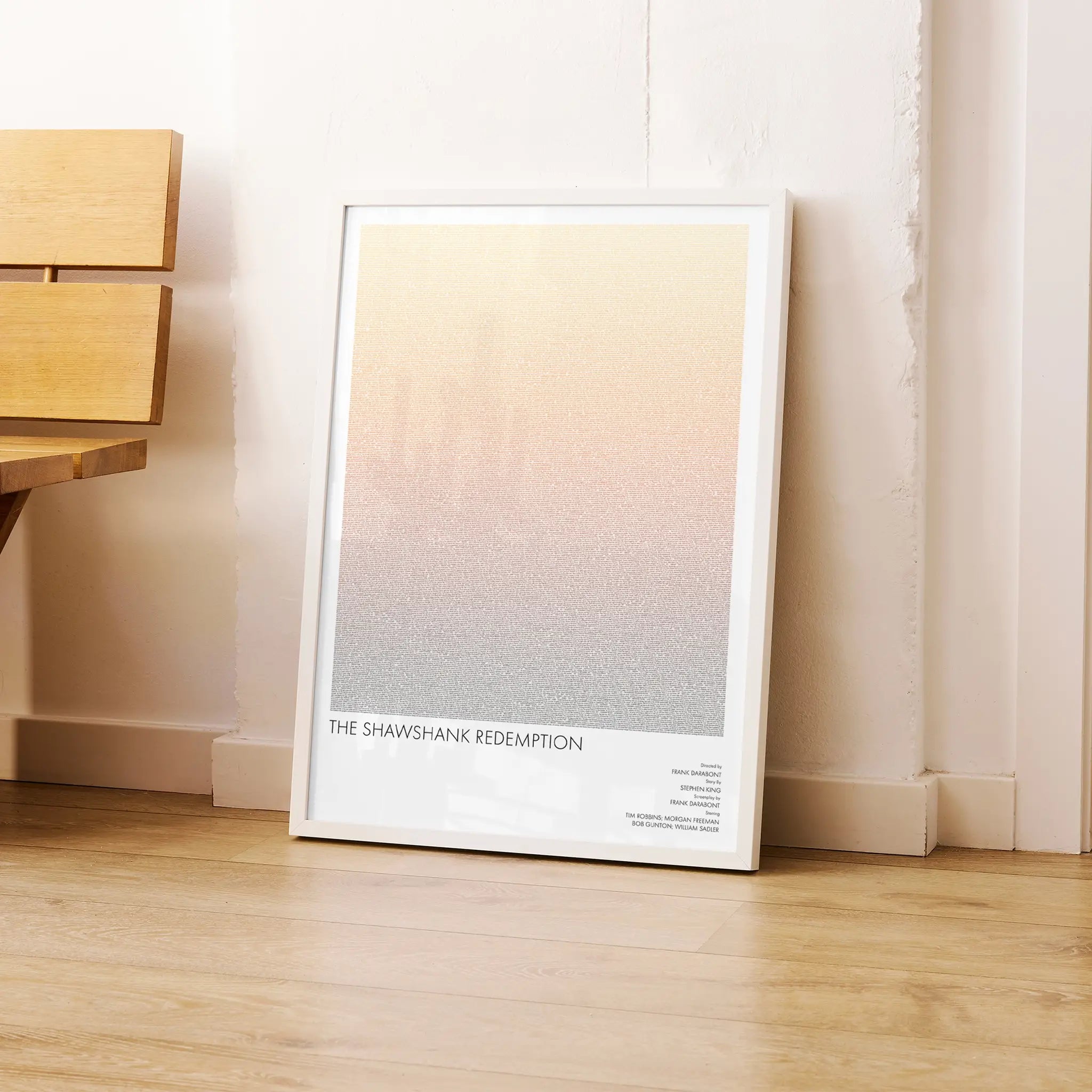 A framed The Shawshank Redemption movie script poster leaning against a wall in a modern interior.