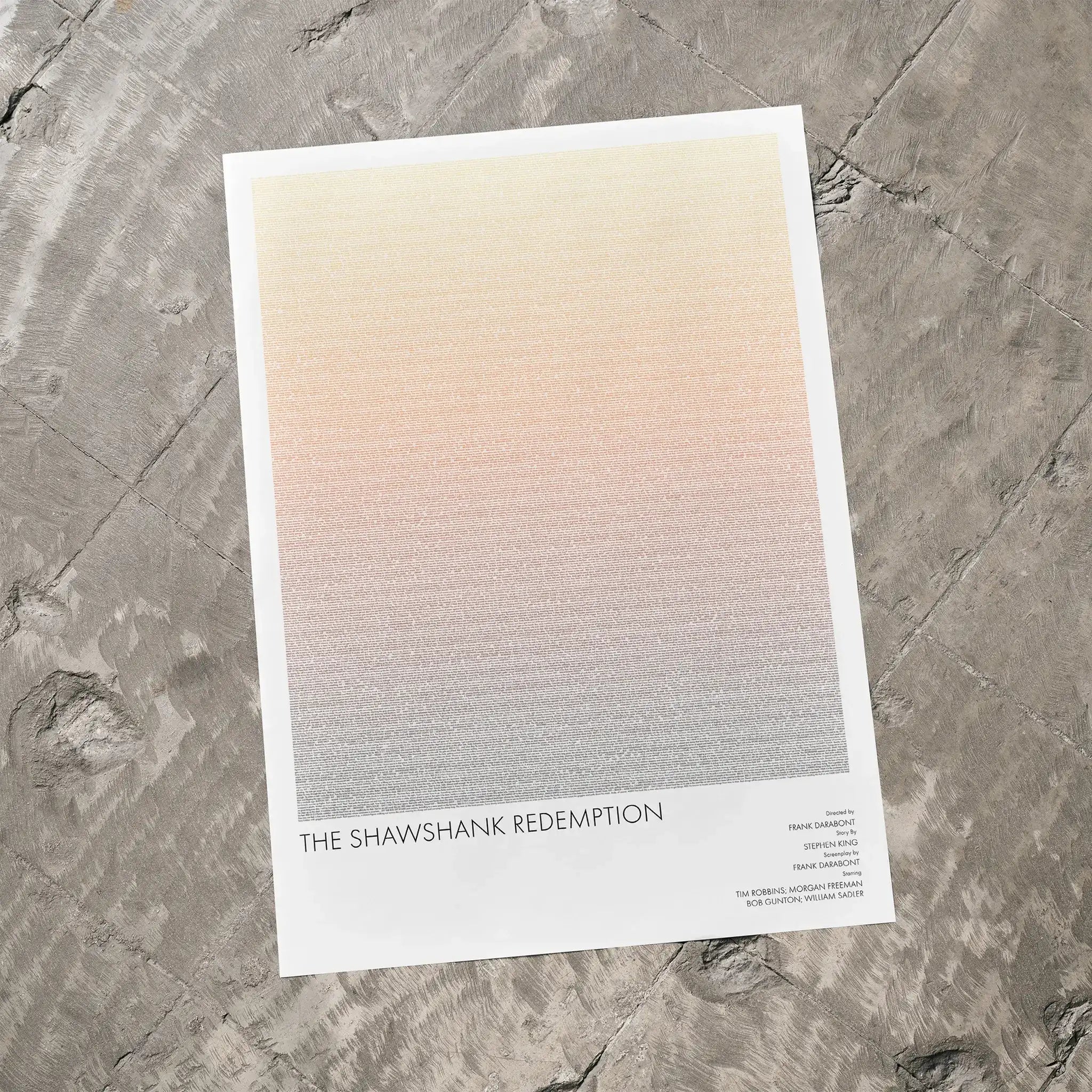 A The Shawshank Redemption movie script poster laid flat on a textured floor surface.