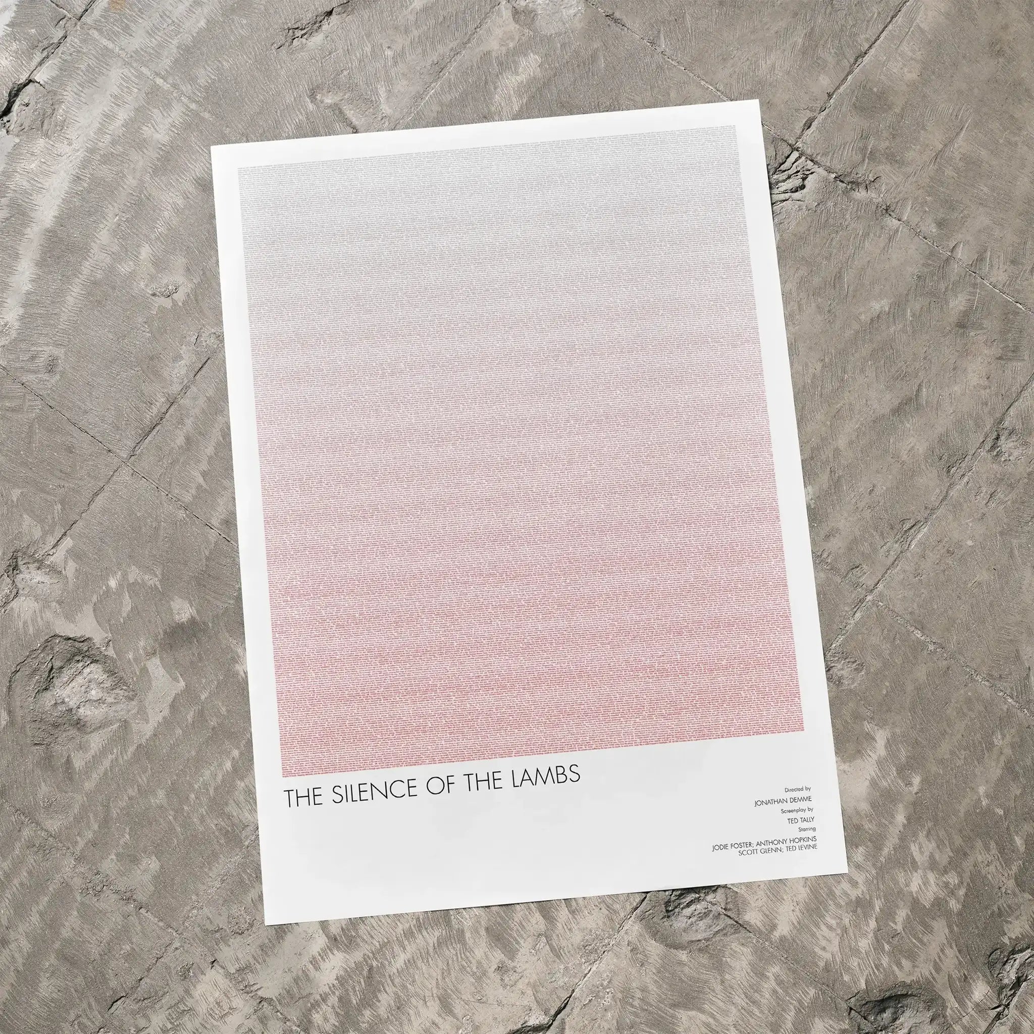 A The Silence of the Lambs movie script poster laid flat on a textured floor surface.