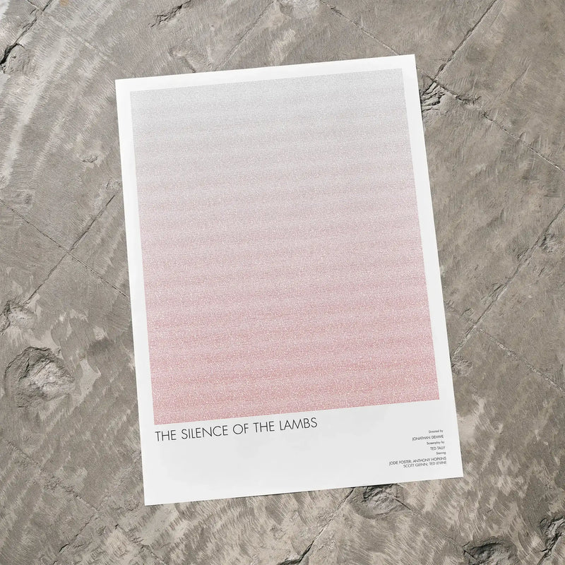 A The Silence of the Lambs movie script poster laid flat on a textured floor surface.