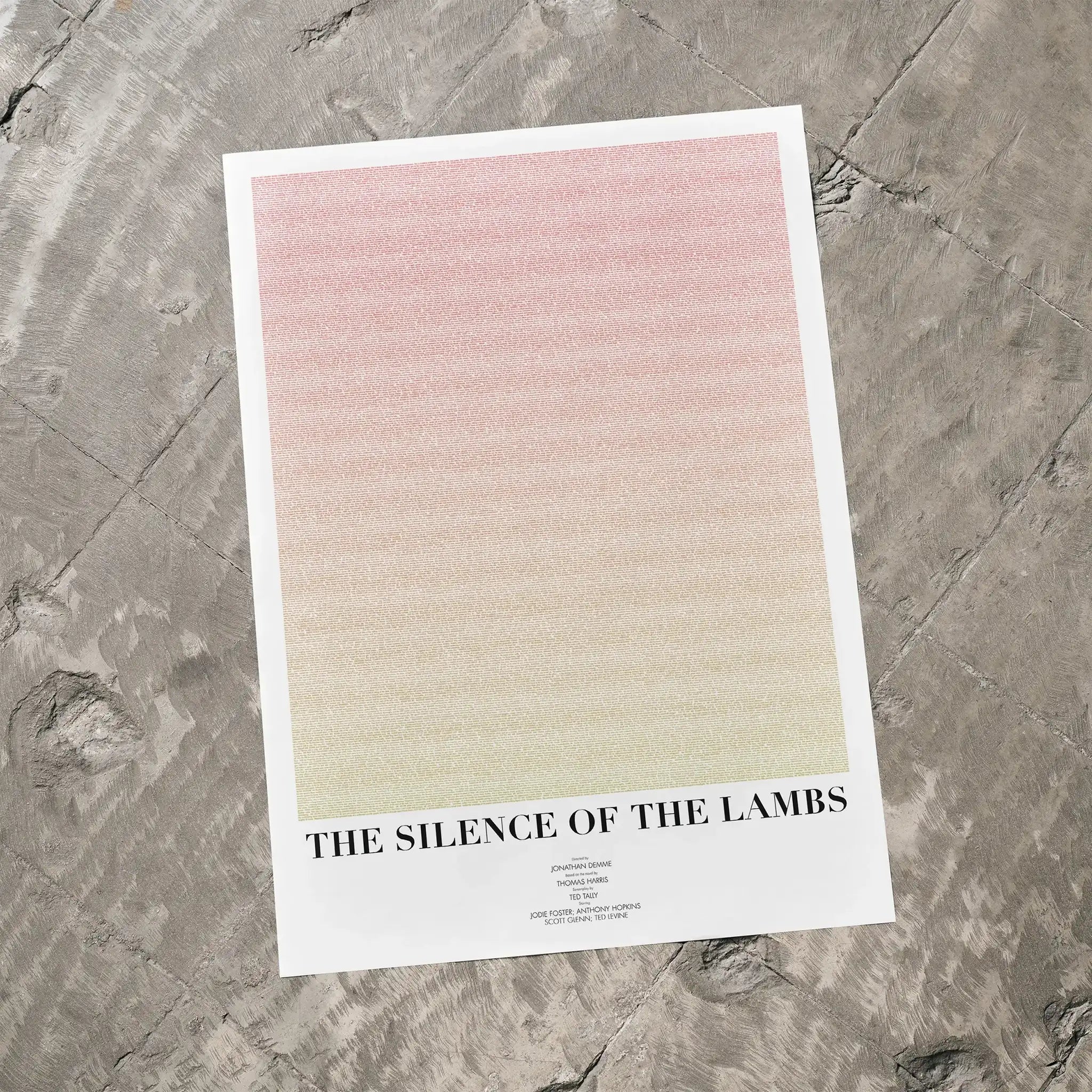 A The Silence of the Lambs movie script poster laid flat on a textured floor surface.