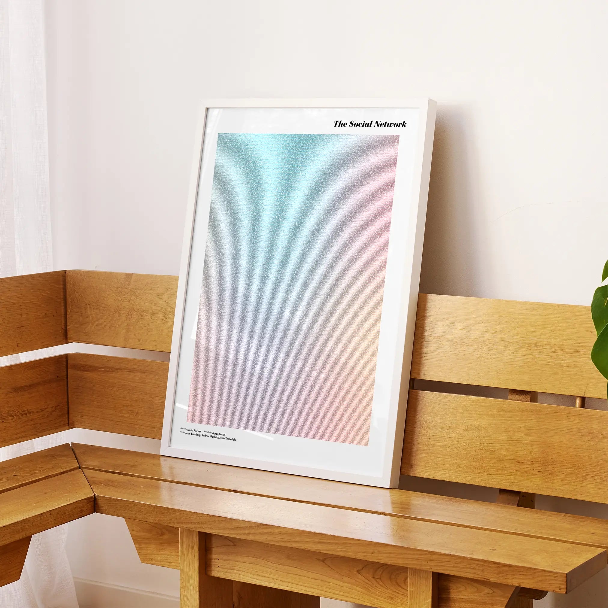 A framed The Social Network movie script poster displayed on a sideboard in a contemporary space.