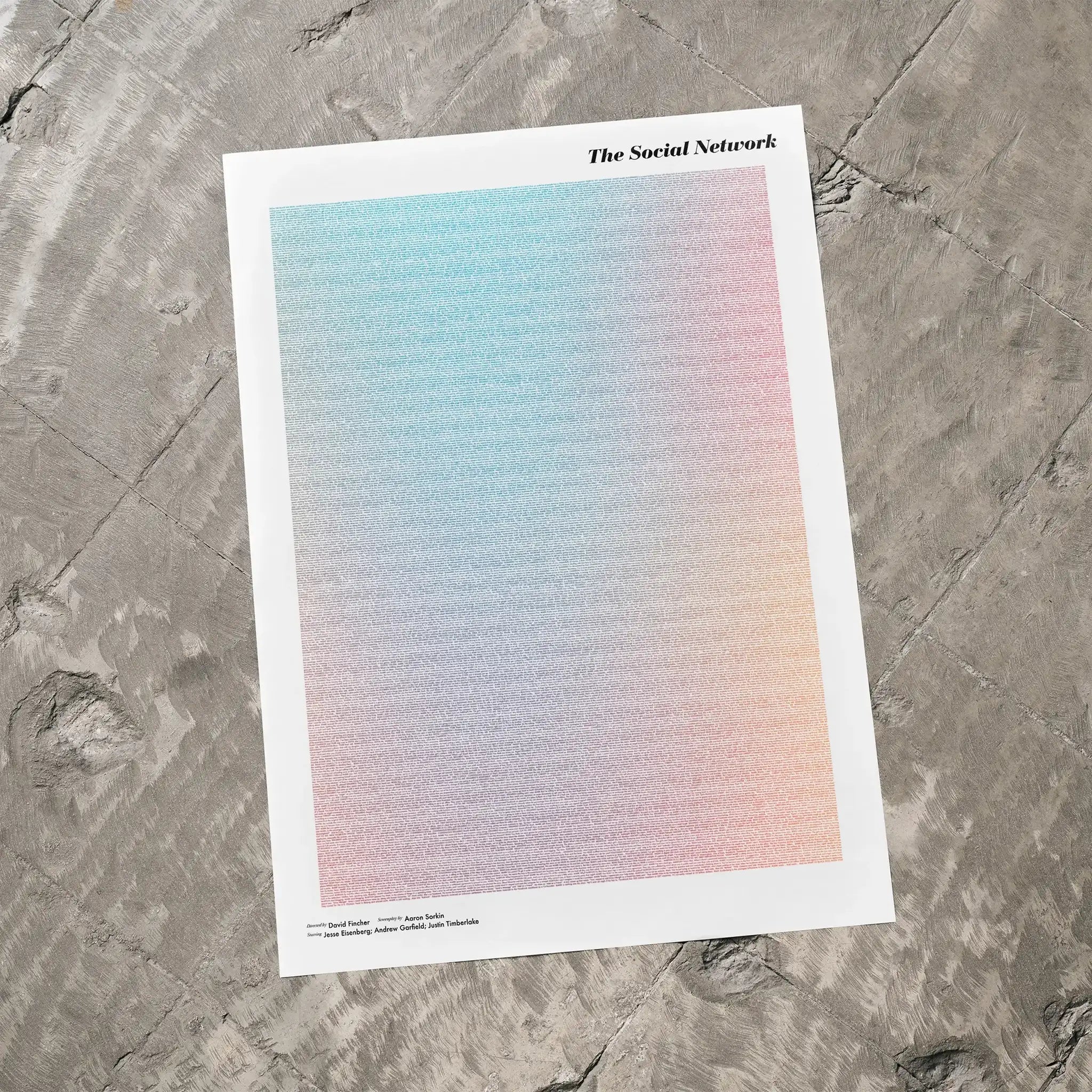 A The Social Network movie script poster laid flat on a textured floor surface.