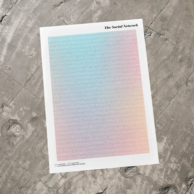 A The Social Network movie script poster laid flat on a textured floor surface.
