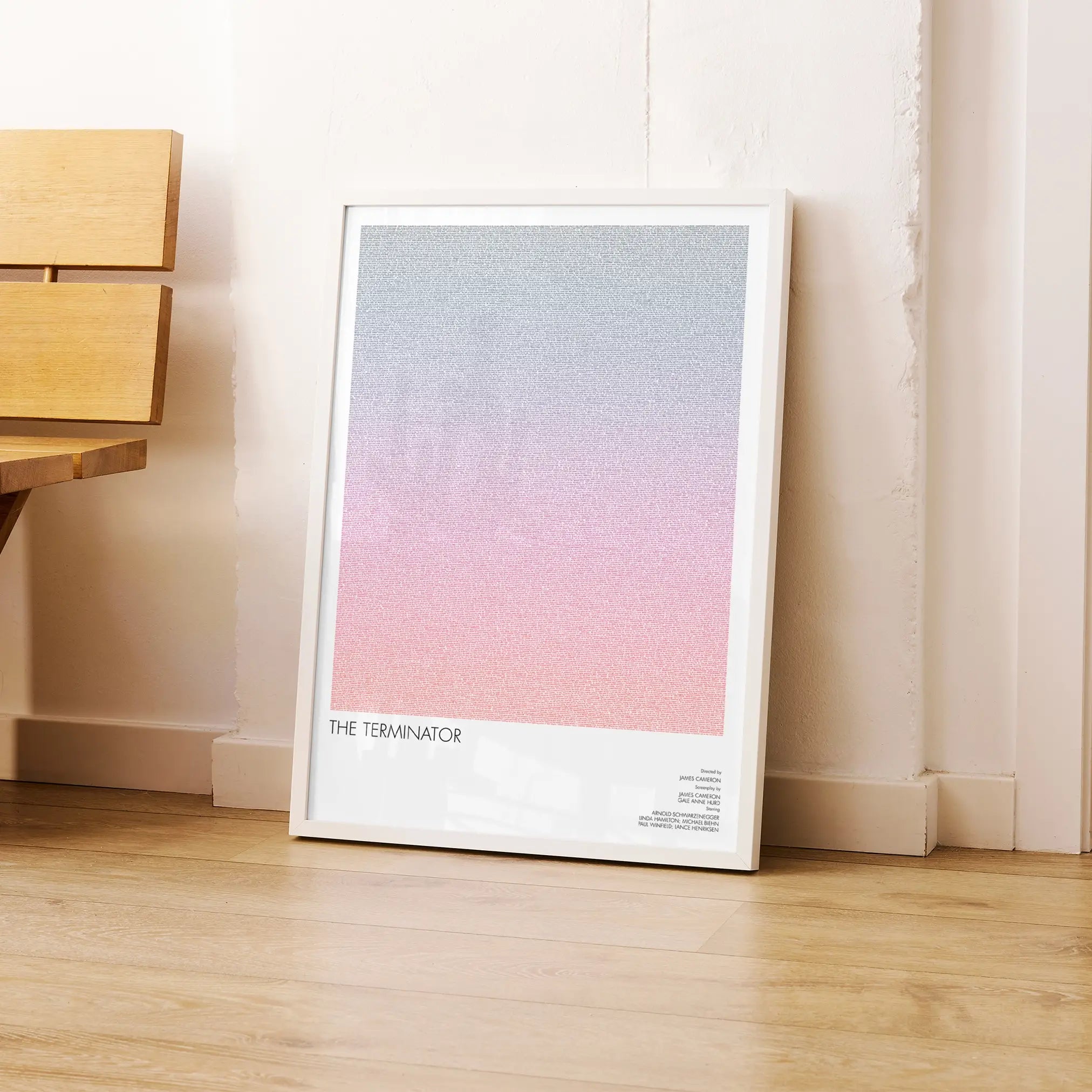 A framed The Terminator movie script poster leaning against a wall in a modern interior.
