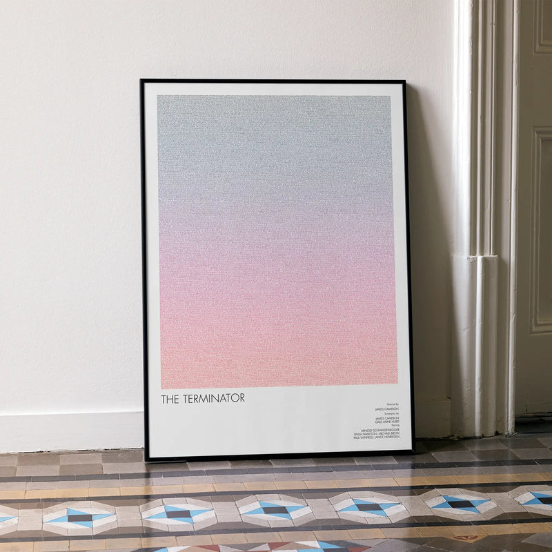 A framed The Terminator movie script poster leaning against a wall in a minimalist interior.