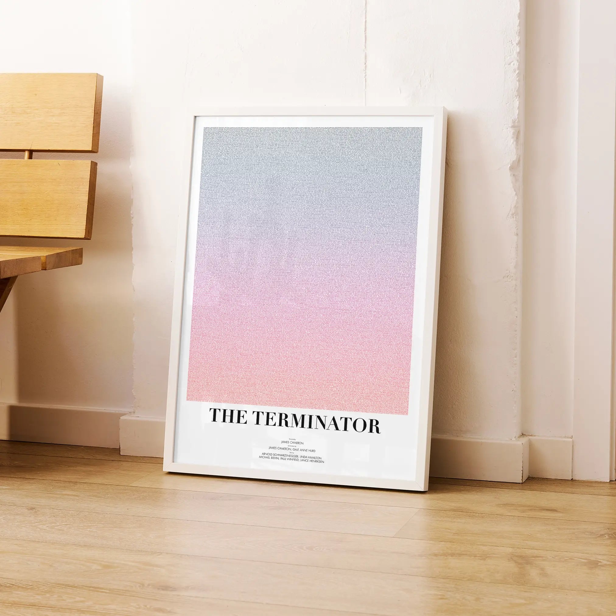 A framed The Terminator movie script poster leaning against a wall in a modern interior.