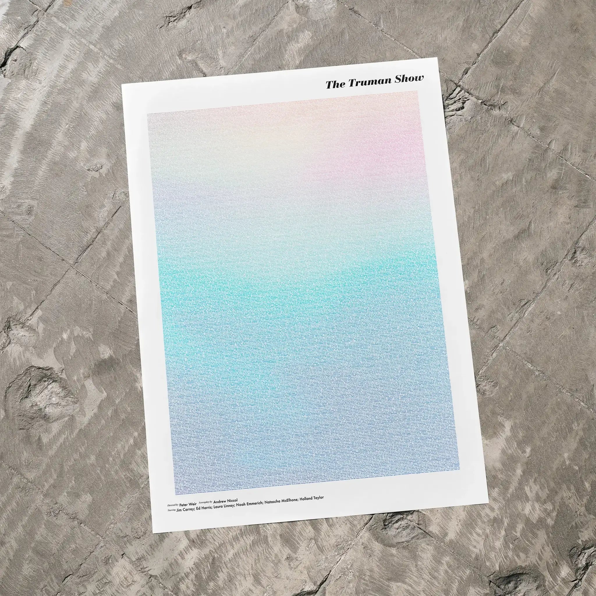 A The Truman Show movie script poster laid flat on a textured floor surface.