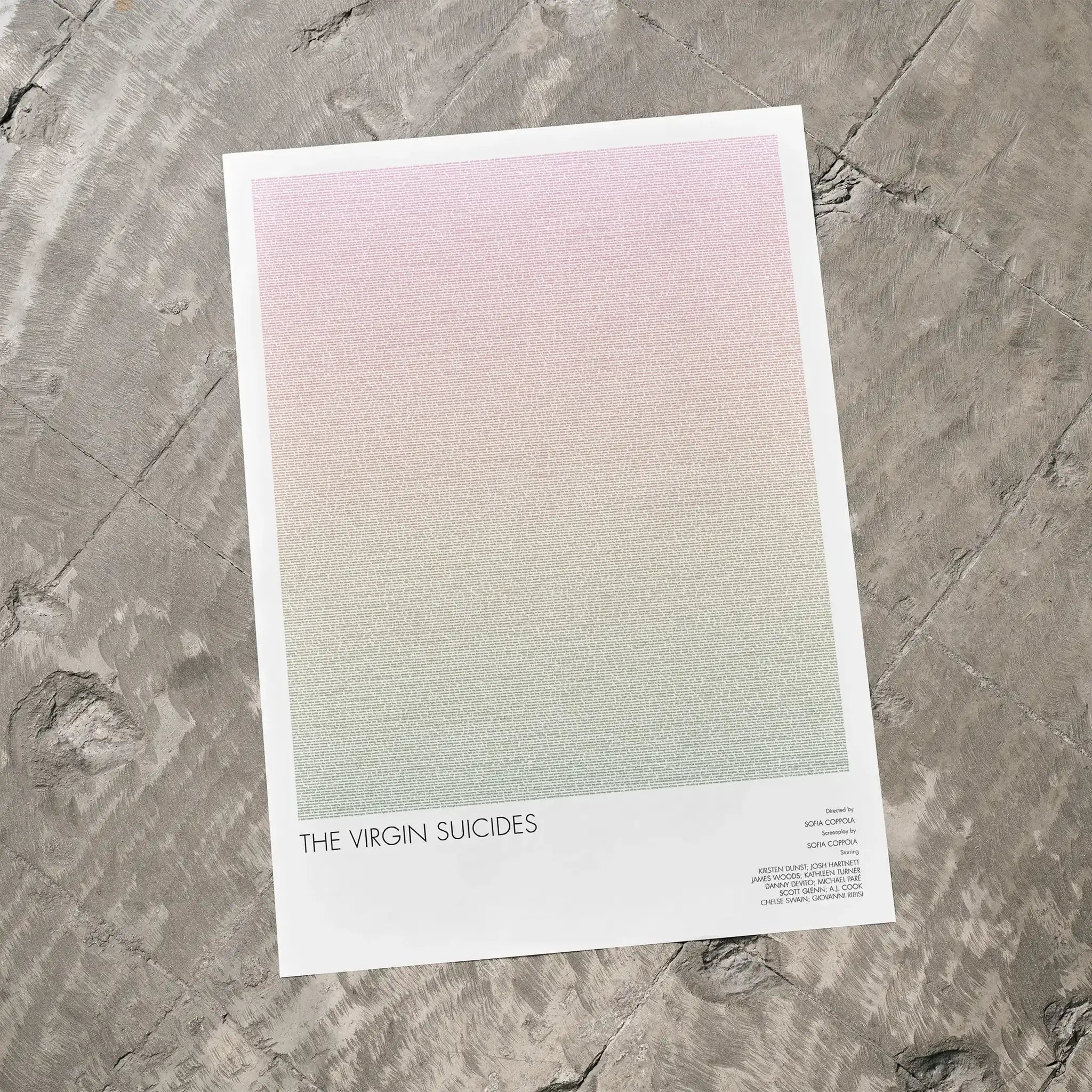 A The Virgin Suicides movie script poster laid flat on a textured floor surface.