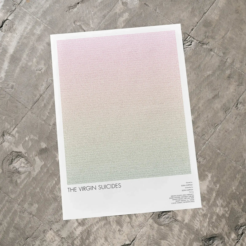 A The Virgin Suicides movie script poster laid flat on a textured floor surface.