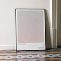 A framed minimalist The Warriors movie art print leaning against a white wall on a patterned tiled floor. 'THE WARRIORS' near the bottom.