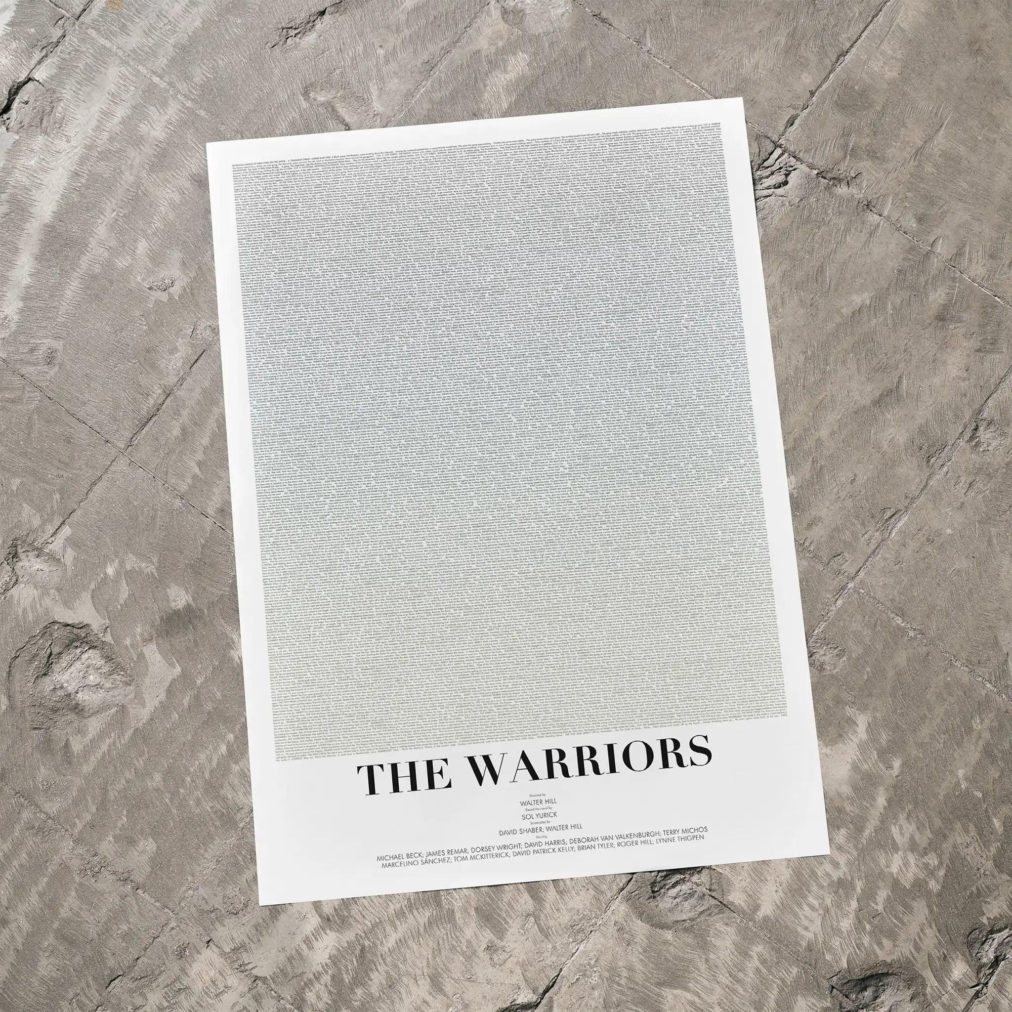 A minimalist art print titled 'THE WARRIORS' featuring a large textured light gray square on a white border, photographed flat on a gray stone surface.