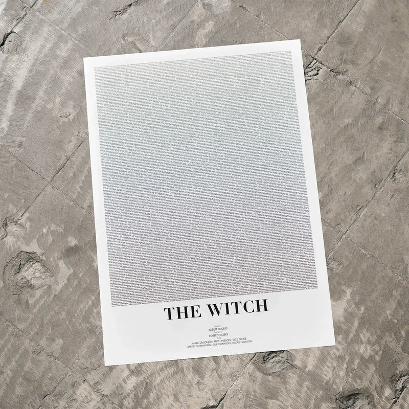 A The Witch movie script poster laid flat on a textured floor surface.