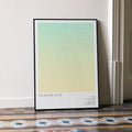 A framed The Wizard of Oz movie script poster leaning against a wall in a minimalist interior.