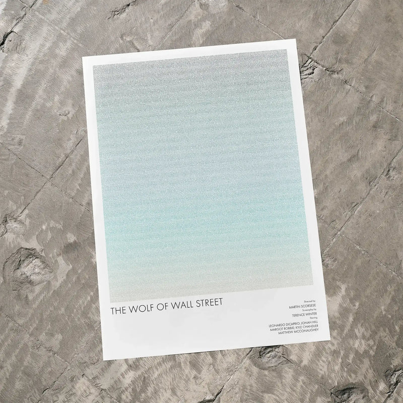 A The Wolf of Wall Street movie script poster laid flat on a textured floor surface.