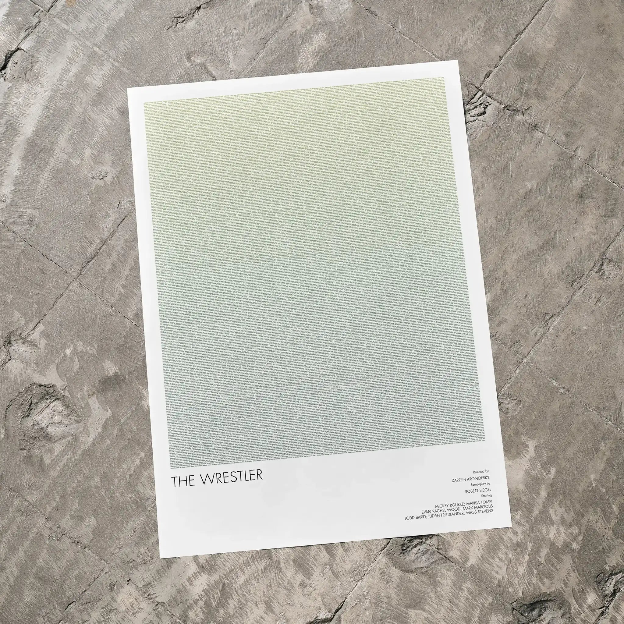 A The Wrestler movie script poster laid flat on a textured floor surface.