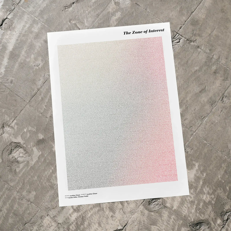 A The Zone of Interest movie script poster laid flat on a textured floor surface.