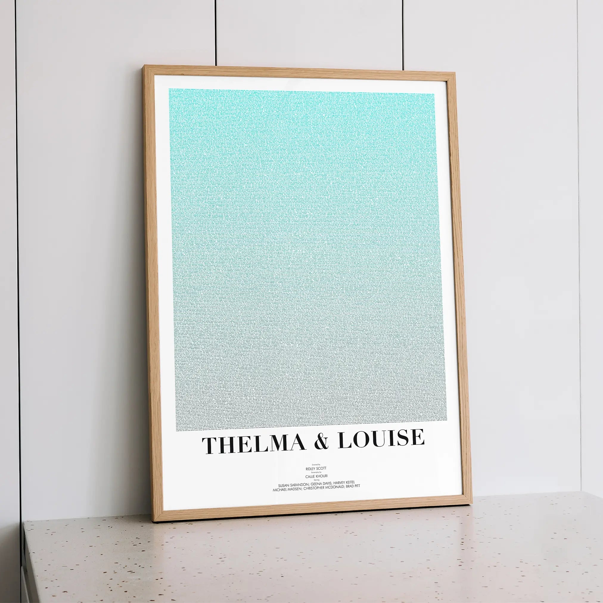 A framed Thelma & Louise movie script poster styled within a calm interior space.
