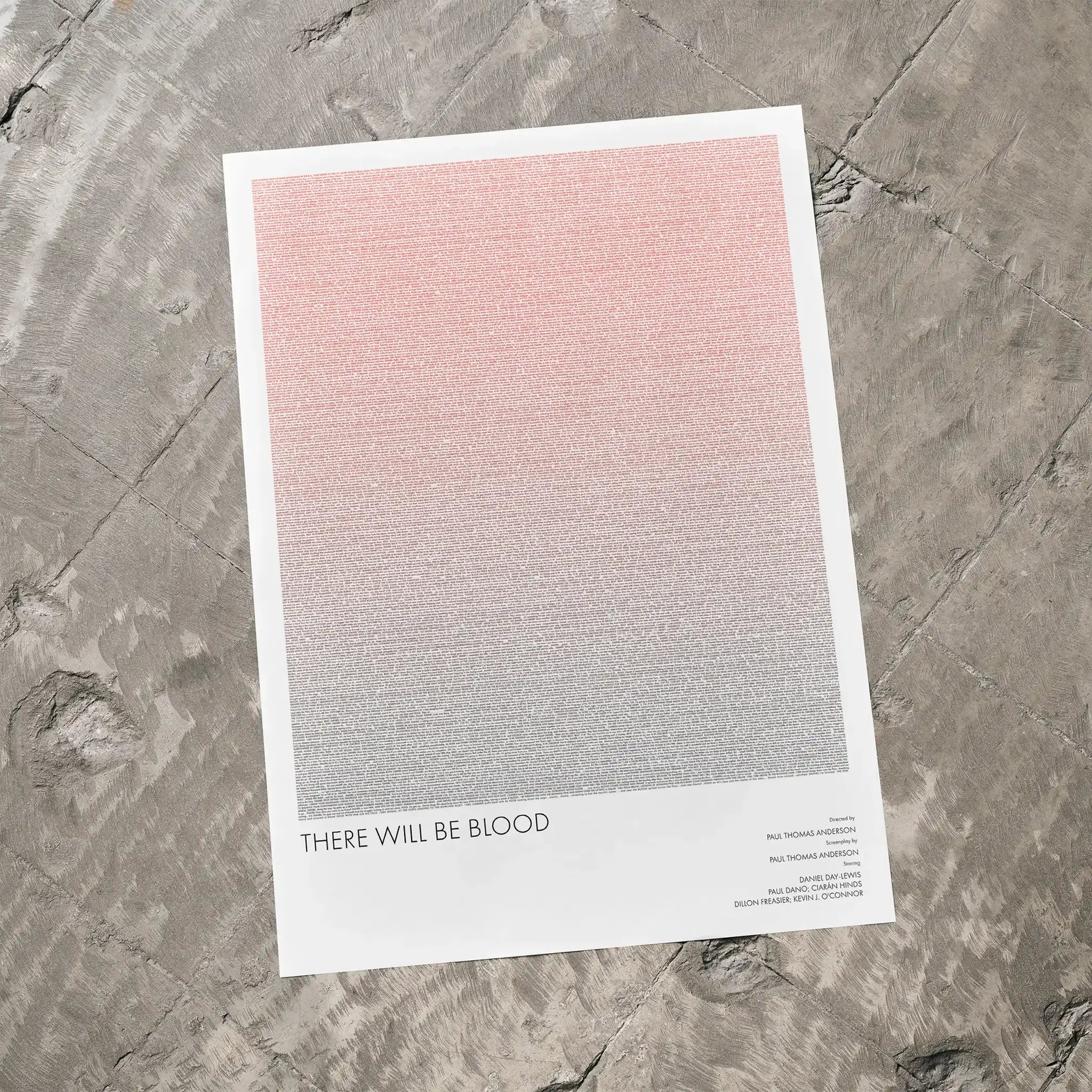 A There Will Be Blood movie script poster laid flat on a textured floor surface.