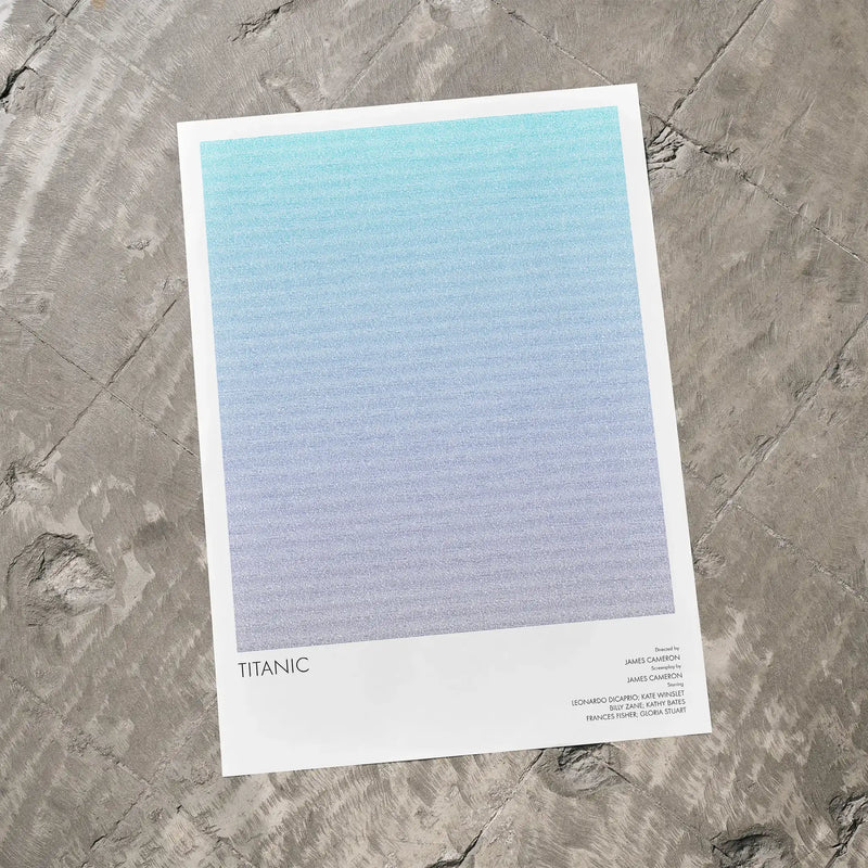 A Titanic movie script poster laid flat on a textured floor surface.