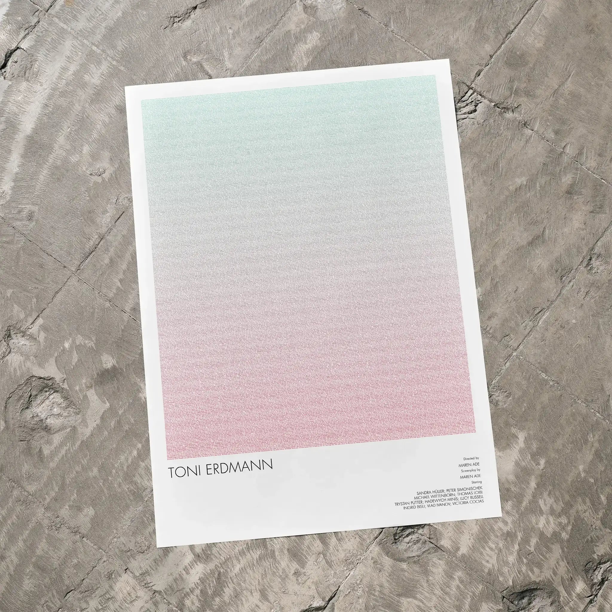 A Toni Erdmann movie script poster laid flat on a textured floor surface.