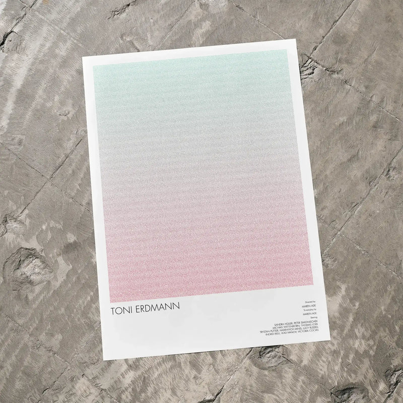 A Toni Erdmann movie script poster laid flat on a textured floor surface.