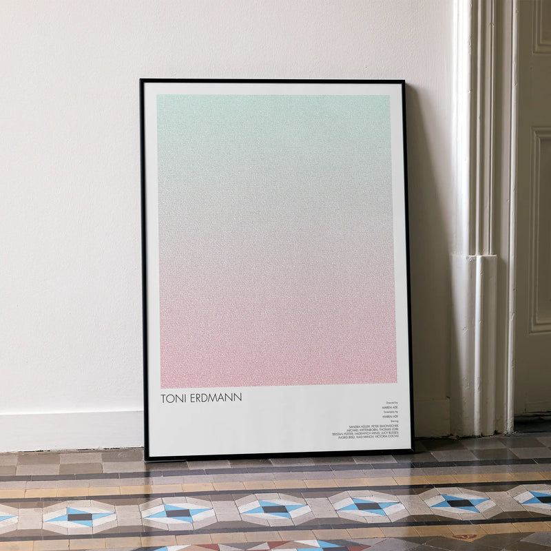 A framed Toni Erdmann movie script poster leaning against a wall in a minimalist interior.