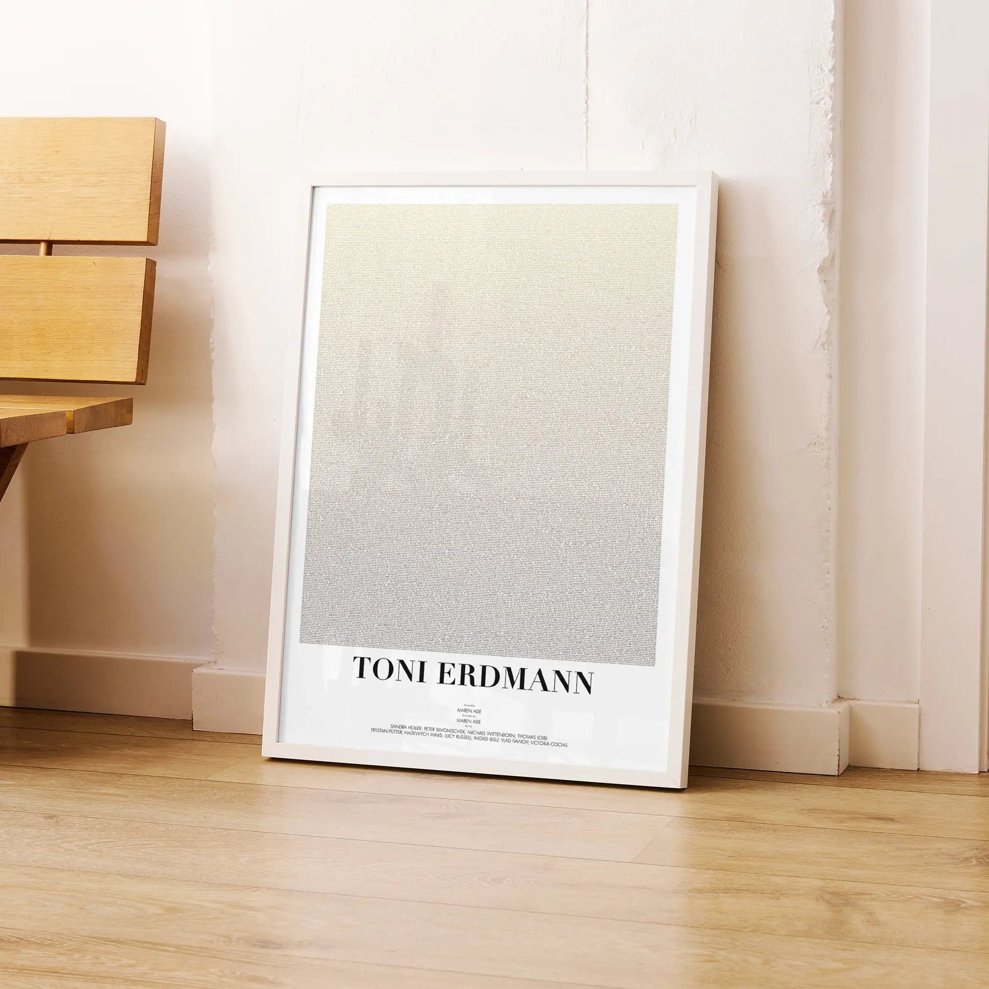 A framed Toni Erdmann movie script poster leaning against a wall in a modern interior.