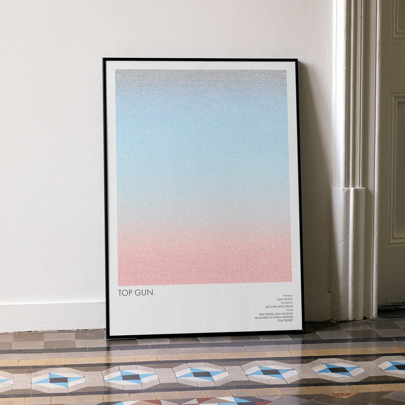 A framed Top Gun movie script poster leaning against a wall in a minimalist interior.