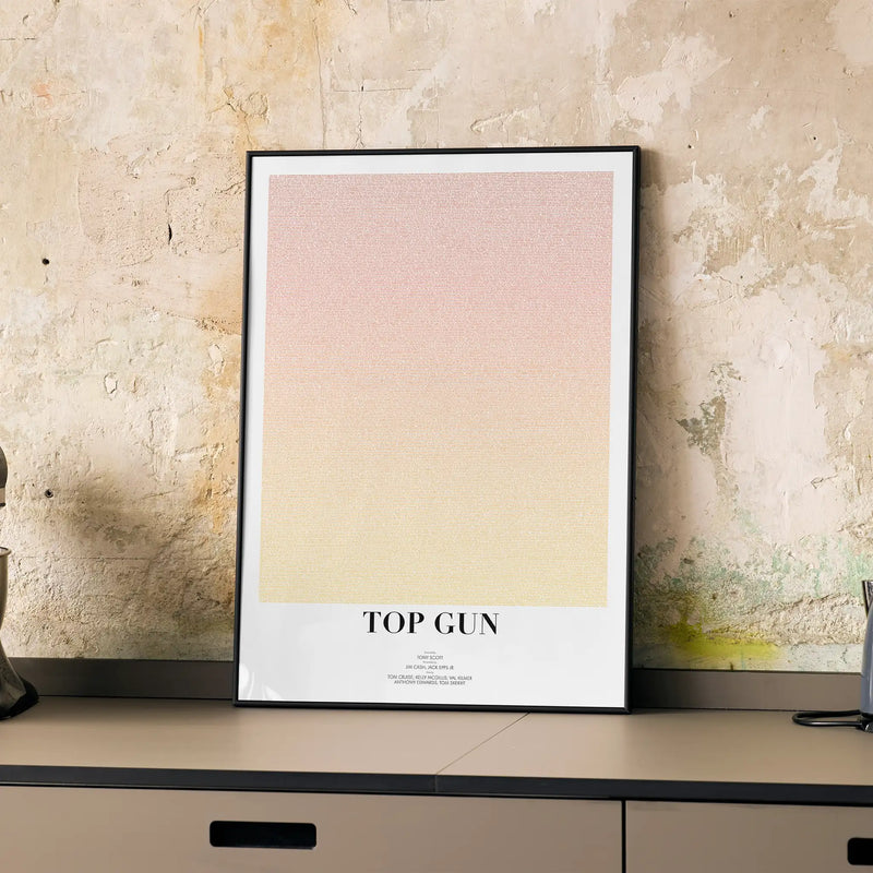 Framed poster with 'Top Gun' text on a textured wall